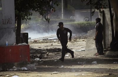 Anti-government protesters run under the fear of sniper fire at a clash point with soldiers, Tuesday, May 18, 2010 in Bangkok, Thailand. Anti-government protesters run under the fear of sniper fire at a clash point with soldiers, Tuesday, May 18, 2010 in Bangkok, Thailand.