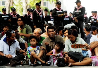 A Red Shirt anti-government protestor sits along with his family at the police headquarters in downtown Bangkok on May 20, 2010 after bieng escorted from a temple which had been turned into a shelter within an anti-government protest site. AFP photo A Red Shirt anti-government protestor sits along with his family at the police headquarters in downtown Bangkok on May 20, 2010 after bieng escorted from a temple which had been turned into a shelter within an anti-government protest site. AFP photo