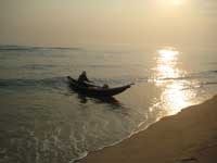 A small fishing boat glides to the shore at Thuan An Beach. A small fishing boat glides to the shore at Thuan An Beach.