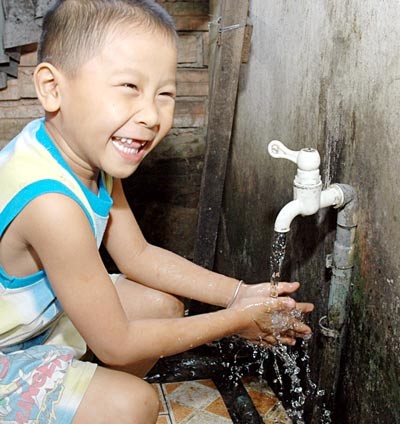 A boy in district Nha Be is happy to use clean water ( Photo: SGGP) A boy in district Nha Be is happy to use clean water ( Photo: SGGP)