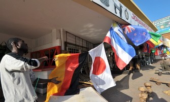 This photo taken on May 16, 2010 shows a West African curios vendor putting up flags in front of his shop in Johannesburg, South Africa (AFP photo) This photo taken on May 16, 2010 shows a West African curios vendor putting up flags in front of his shop in Johannesburg, South Africa (AFP photo)