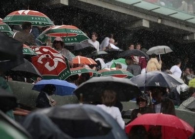 People wait under umbrellas after rain stopped play in the French Open tennis championship at the Roland Garros stadium, on May 26. AFP photo People wait under umbrellas after rain stopped play in the French Open tennis championship at the Roland Garros stadium, on May 26. AFP photo