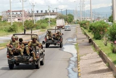 Jamaican soldiers travel a road in Kingston's Tivoli Gardens neighborhood on May 27, 2010 Jamaican soldiers travel a road in Kingston's Tivoli Gardens neighborhood on May 27, 2010