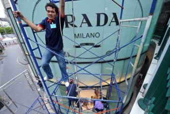 Thai workers climb on a scaffold during repair work on the window of shopping mall in Bangkok on May 30, 2010. AFP photo Thai workers climb on a scaffold during repair work on the window of shopping mall in Bangkok on May 30, 2010. AFP photo