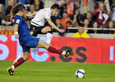 David Villa (Valencia) sút bóng trước sự truy cản của Carles Puyol. Họ sẽ là đồng đội sau mùa hè này? David Villa (Valencia) sút bóng trước sự truy cản của Carles Puyol. Họ sẽ là đồng đội sau mùa hè này?