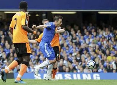 Lampard (áo xanh) vượt qua sự truy cản của hậu vệ Wigan. Lampard (áo xanh) vượt qua sự truy cản của hậu vệ Wigan.