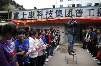 In this photo taken on Feb. 24, 2010, a recruiter talks to job seekers near a sign which reads 'Foxconn Technology Group Recruitment Point' in Shenzhen in south China's Guangdong province In this photo taken on Feb. 24, 2010, a recruiter talks to job seekers near a sign which reads 'Foxconn Technology Group Recruitment Point' in Shenzhen in south China's Guangdong province
