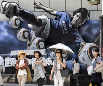 Pedestrians pass before a large advertisement of Sony's 3D televiosion and its 3D broadcasting of FIFA World Cup games at the Sony's showroom in Tokyo on June 10, 2010. AFP photo Pedestrians pass before a large advertisement of Sony's 3D televiosion and its 3D broadcasting of FIFA World Cup games at the Sony's showroom in Tokyo on June 10, 2010. AFP photo