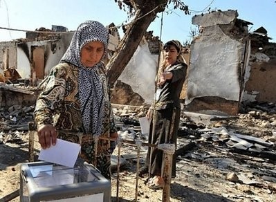 Ethnic Uzbek women vote next to their burned-out house during a referendum in Osh. AFP Ethnic Uzbek women vote next to their burned-out house during a referendum in Osh. AFP