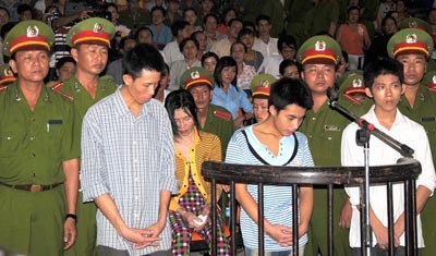 Giang, two employees, who help him torture Hoang Anh, and his wife (sitting), appear in the trial. (Photo: SGGP) Giang, two employees, who help him torture Hoang Anh, and his wife (sitting), appear in the trial. (Photo: SGGP)