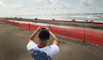 Dustin Pierre, who is part of the BP oil clean up team, takes pictures on the beach after operations were cancelled due to high winds and rough seas on July 7, 2010 in Grand Isle, Louisiana. AFP Dustin Pierre, who is part of the BP oil clean up team, takes pictures on the beach after operations were cancelled due to high winds and rough seas on July 7, 2010 in Grand Isle, Louisiana. AFP
