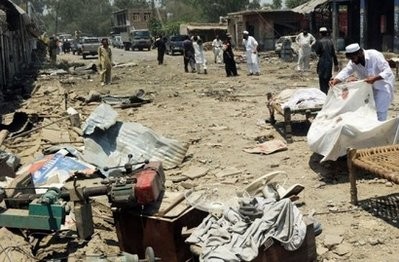 A local resident is seen looking at the body of a blast victim following a suicide bomb attack in the district of Mohmand, on July 9 A local resident is seen looking at the body of a blast victim following a suicide bomb attack in the district of Mohmand, on July 9