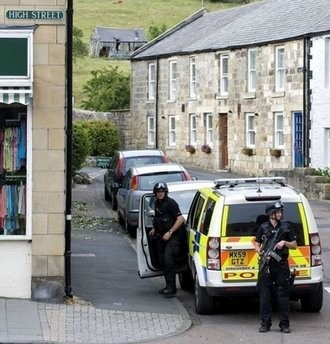Armed British police stand guard in the centre of Rothbury. Armed British police stand guard in the centre of Rothbury.