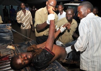 People carry an injured man in Kampala's Mulago hospital, on July 12, 2010 after twin bomb blasts. AFP People carry an injured man in Kampala's Mulago hospital, on July 12, 2010 after twin bomb blasts. AFP