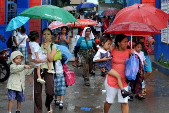 Parents pick up their children wearing protective rain gear after elementary school classes in the Philippine capital Manila are called off due to Typhoon Conson, on July 13, 2010. AFP Parents pick up their children wearing protective rain gear after elementary school classes in the Philippine capital Manila are called off due to Typhoon Conson, on July 13, 2010. AFP