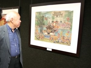 A visitor contemplates a silk painting at the display. A visitor contemplates a silk painting at the display.