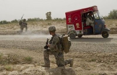 US soldiers stand guard as an auto rickshaw drives past in Dand district, Kandahar Province in Afghanistan on July 24, 2010. US soldiers stand guard as an auto rickshaw drives past in Dand district, Kandahar Province in Afghanistan on July 24, 2010.