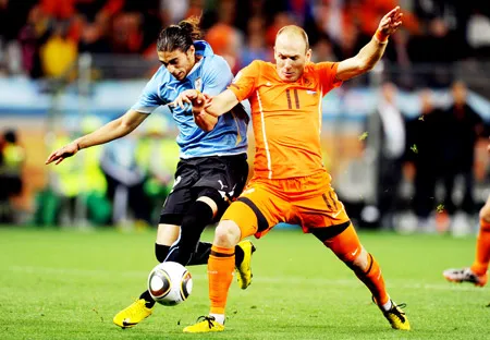 Tiền vệ Hà Lan Arjen Robben (phải) tranh bóng với hậu vệ Uruguay Martin Caceres. Tiền vệ Hà Lan Arjen Robben (phải) tranh bóng với hậu vệ Uruguay Martin Caceres.