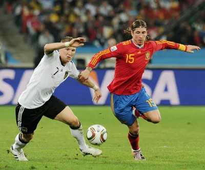 Tiền vệ Bastian Schweinsteiger (trái, tuyển Đức) tranh bóng bóng với hậu vệ Sergio Ramos của Tây Ban Nha. Tiền vệ Bastian Schweinsteiger (trái, tuyển Đức) tranh bóng bóng với hậu vệ Sergio Ramos của Tây Ban Nha.