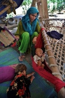 A Pakistani flood-affected family rest in a makeshift camp in Mardan. A Pakistani flood-affected family rest in a makeshift camp in Mardan.