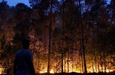 A Russian man watches forest fires burn in Beloomut late on August 1, 2010. A Russian man watches forest fires burn in Beloomut late on August 1, 2010.