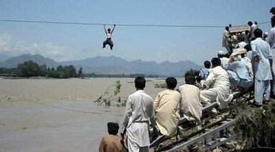 Onlookers perched on a damaged bridge watch a Pakistani flood survivor climb a rope to cross a river in Pakistan's Swat valley's Chakdara. AFP Onlookers perched on a damaged bridge watch a Pakistani flood survivor climb a rope to cross a river in Pakistan's Swat valley's Chakdara. AFP
