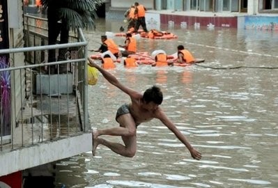 A survivor jumps into floodwaters as rescuers (background) evacuate people from flooded buildings in Zhouqu, causing flooding in northwest China's Gansu province on August 8, 2010. AFP A survivor jumps into floodwaters as rescuers (background) evacuate people from flooded buildings in Zhouqu, causing flooding in northwest China's Gansu province on August 8, 2010. AFP