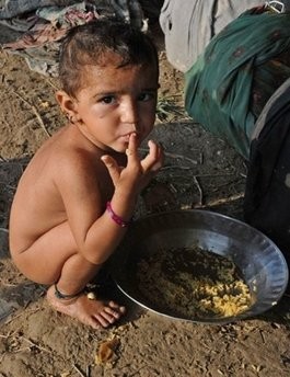 A flood-affected Pakistani child eats at a roadside in Sukkur A flood-affected Pakistani child eats at a roadside in Sukkur