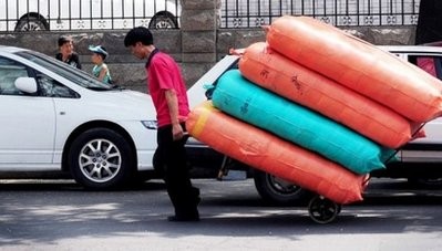 A worker delivers bags of produce to a wholesale market in Beijing on August 10, 2010 A worker delivers bags of produce to a wholesale market in Beijing on August 10, 2010