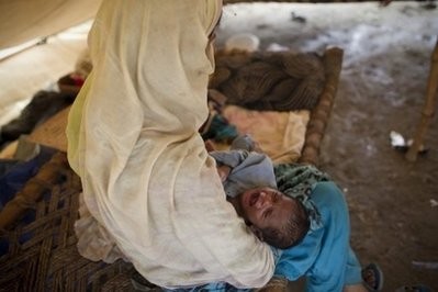 A Pakistani mother tries to calm her crying child in her tent at a school converted to a camp for flood survivors on the outskirts of Nowshera on August 12, 2010. AFP A Pakistani mother tries to calm her crying child in her tent at a school converted to a camp for flood survivors on the outskirts of Nowshera on August 12, 2010. AFP