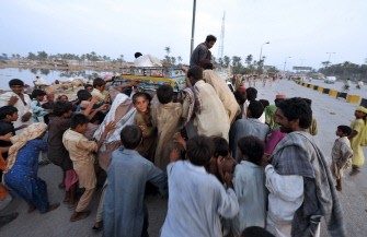 Pakistani flood survivors struggle for charity food near a makeshift camp in Sukkur on August 13, 2010. AFP Pakistani flood survivors struggle for charity food near a makeshift camp in Sukkur on August 13, 2010. AFP