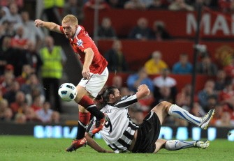 Paul Scholes (L) avoids a tackle from Newcastle United's Andy Carroll during the football match at Old Trafford on August 16, 2010. AFP PHOTO Paul Scholes (L) avoids a tackle from Newcastle United's Andy Carroll during the football match at Old Trafford on August 16, 2010. AFP PHOTO