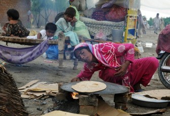A female Pakistani flood survivor blows on a fire as she makes bread on high ground in the flooded area of Pathan Wala on August 16, 2010. A female Pakistani flood survivor blows on a fire as she makes bread on high ground in the flooded area of Pathan Wala on August 16, 2010.