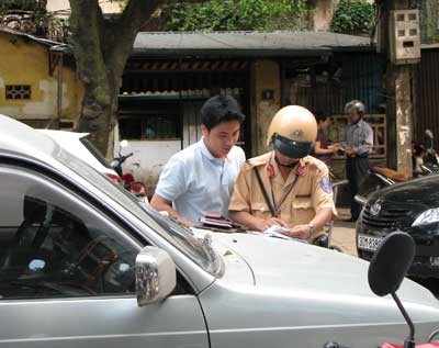 A traffic police officer fines a driver for violating the traffic law in Vinh City. A traffic police officer fines a driver for violating the traffic law in Vinh City.