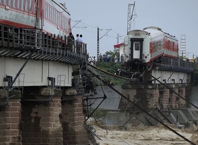 People look at a derailed passenger train on a collapsed bridge at the Shiting River in Guanghan in southwest China's Sichuan province, Thursday, Aug. 19, 2010. People look at a derailed passenger train on a collapsed bridge at the Shiting River in Guanghan in southwest China's Sichuan province, Thursday, Aug. 19, 2010.