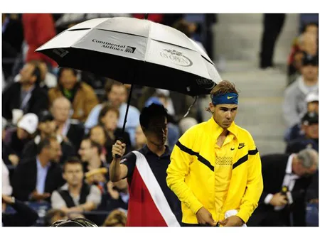 Một nhân viên phục vụ thầm lặng che dù cho Nadal ở US Open Một nhân viên phục vụ thầm lặng che dù cho Nadal ở US Open