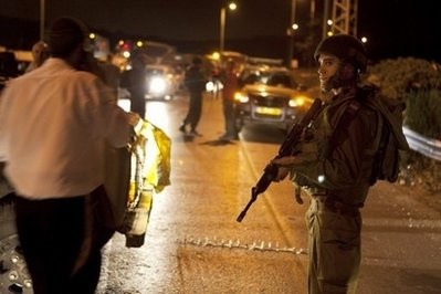 An Israeli border policeman blocks the road after a settlers' car was ambushed by Palestinian gunmen killing two woman and two men next to Kiryat Arba settlement in the southern West Bank An Israeli border policeman blocks the road after a settlers' car was ambushed by Palestinian gunmen killing two woman and two men next to Kiryat Arba settlement in the southern West Bank