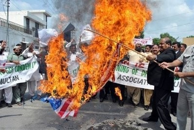 Pakistani lawyers carry a burning US flag during a protest in Multan against plans to burn the Koran. Pakistani lawyers carry a burning US flag during a protest in Multan against plans to burn the Koran.
