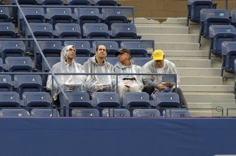 Fans wait out a rain delay and watch a Sep. 12 replay of the Sep. 11 semi final between Roger Federer and Novak Djokovic. AFP Fans wait out a rain delay and watch a Sep. 12 replay of the Sep. 11 semi final between Roger Federer and Novak Djokovic. AFP