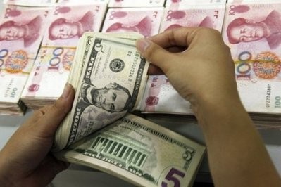 A Chinese bank worker counts US dollars alongside 100-yuan notes in central China's Anhui province A Chinese bank worker counts US dollars alongside 100-yuan notes in central China's Anhui province