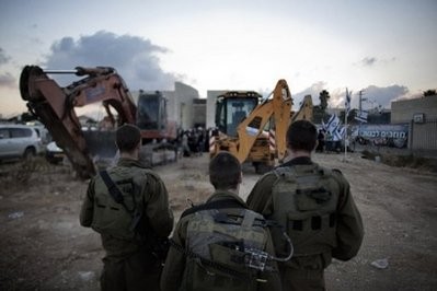Israeli soldiers stand near construction machinery in the Jewish settlement of Adom, close to the Israeli-occupied West Bank city of Ramallah Israeli soldiers stand near construction machinery in the Jewish settlement of Adom, close to the Israeli-occupied West Bank city of Ramallah