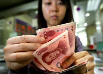 This photo taken on May 20, 2005 shows a bank teller counting Chinese currency 100 yuan notes in Beijing. AFP This photo taken on May 20, 2005 shows a bank teller counting Chinese currency 100 yuan notes in Beijing. AFP