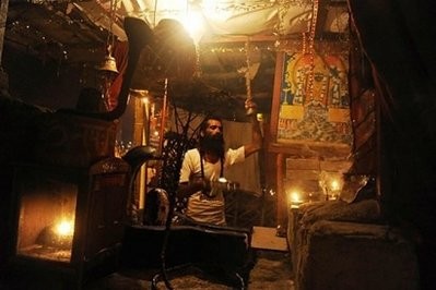 An Indian Hindu priest prays inside a roadside temple in Lucknow An Indian Hindu priest prays inside a roadside temple in Lucknow