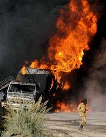 AFP – A Pakistani firefighter walks past burning NATO supply oil tankers following an attack in Quetta on October 6. AFP – A Pakistani firefighter walks past burning NATO supply oil tankers following an attack in Quetta on October 6.