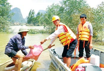 Quang Binh Province Red Cross officials give relief goods to a resident in the central region (Photo: SGGP) Quang Binh Province Red Cross officials give relief goods to a resident in the central region (Photo: SGGP)