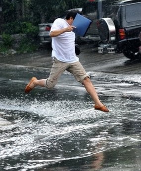 A pedestrian jumps over a puddle in a flooded street in Manila on October 16, 2010 A pedestrian jumps over a puddle in a flooded street in Manila on October 16, 2010