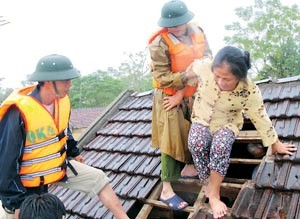 Police and army rescue workers save Nguyen Thi Huong (R), 63, from her flooded-to-roof house via a hole on the roof in Duc Huong Commune, Vu Quang District, Ha Tinh Province on October 17, 2010. (Photo: SGGP) Police and army rescue workers save Nguyen Thi Huong (R), 63, from her flooded-to-roof house via a hole on the roof in Duc Huong Commune, Vu Quang District, Ha Tinh Province on October 17, 2010. (Photo: SGGP)