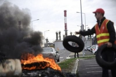 A striker throws a tyre on a fire during a protest outside a fuel storage depot on October 18, 2010 in Donges, western France. A striker throws a tyre on a fire during a protest outside a fuel storage depot on October 18, 2010 in Donges, western France.