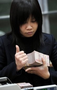 A bank employee counts notes in Hanoi, Vietnam. A bank employee counts notes in Hanoi, Vietnam.
