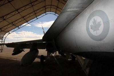A Canadian fighter jet inside a hangar. A Canadian fighter jet inside a hangar.
